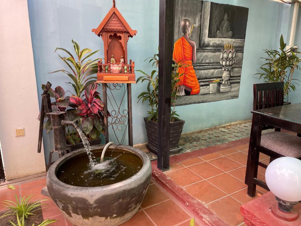 Khmer courtyard with spirit house and monk painting